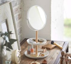 a round mirror sitting on top of a wooden table