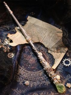 an old harry potter wand is laying on a piece of paper and surrounded by charms