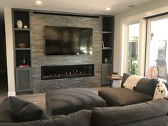 a living room with two couches and a flat screen tv mounted on the wall