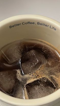 a cup filled with ice and water on top of a table