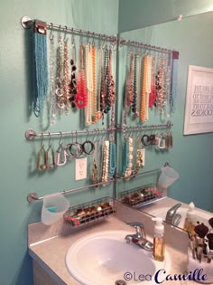 a bathroom sink with jewelry hanging on the wall