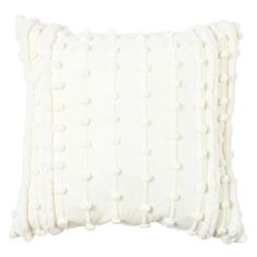 a white pillow with pom - poms on it