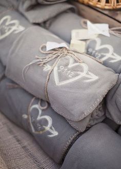 pillows and blankets are sitting on a couch with hearts drawn on the fabric, along with two small tags that say i love you