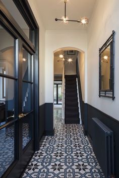 a long hallway with black and white tiles on the floor