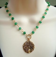 A beautiful sculpted gold tree of life pendant hangs from a hand made chain consist of green jade gemstones, all plated in 24 karat gold. This striking necklace is finished with a spring ring clasp. The necklace measures 16 inch in length, with 2 inches extension. Pendant measures 1.5 inch. Also available in sterling silver plate. Available in many color stones chain. Gold Jade Necklace With Gemstone Beads, Bohemian Gold Jewelry With Green Onyx, Gold Emerald Necklaces With Gemstone Beads, Elegant Wire Wrapped Jewelry For Meditation, Bohemian Green Onyx Gold Jewelry, Gold Necklace With Green Onyx Gemstone Beads, Handmade Gold Necklaces With Green Onyx, Handmade Gold Green Onyx Necklaces, Handmade Yellow Gold Jade Necklaces