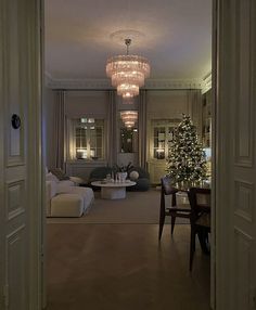 a living room filled with furniture and a chandelier hanging from it's ceiling