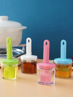 four small containers with toothbrushes in them on a table