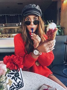 a woman wearing sunglasses and holding an ice cream cone