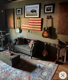 a living room with guitars and other musical instruments hanging on the wall next to a couch