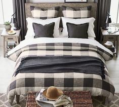 a bed with black and white checkered comforter, pillows, and a hat on it