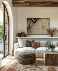 a living room filled with furniture and a large painting on the wall above it's fireplace