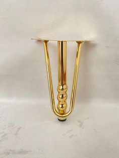 a gold plated metal object on a white surface with no one around it or in the background