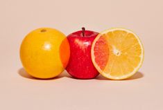 an apple, orange and lemon are arranged on a white background with one half cut in half