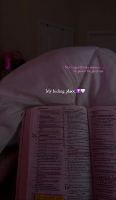 an open book sitting on top of a bed next to a pink pillow with the words, my hiding place