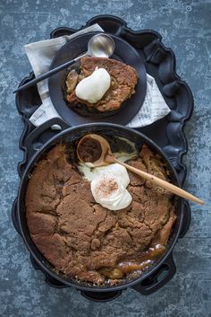 two desserts in black pans on a table