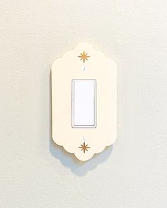 a white light switch sitting on top of a wall