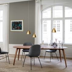 a dining room table and chairs in front of large windows