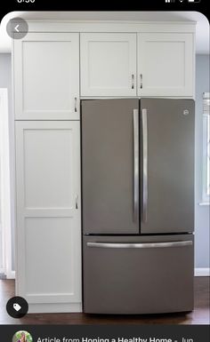 an appliance that is on the side of a refrigerator in a kitchen with white cabinets