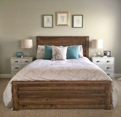 a bedroom with a bed, nightstands and pictures on the wall