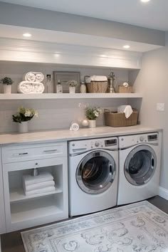 a washer and dryer in a room with shelves above the washer door