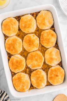 a casserole dish filled with meat and cheese on top of a marble counter