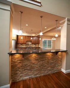 an empty kitchen with wood flooring and granite counter tops, along with recessed lighting