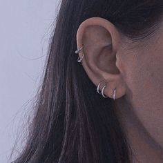 a close up of a person's ear with two piercings on it and one behind the ear