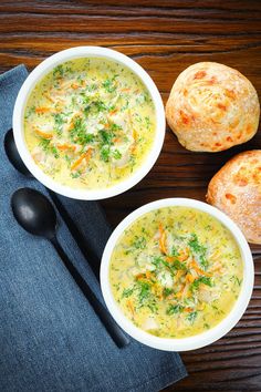 two bowls of soup with bread on the side