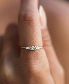 a woman's hand with a diamond ring on her left side, and the other half of her finger