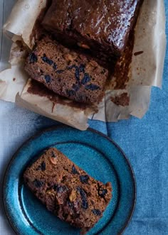 two slices of chocolate banana bread on a blue plate next to another piece of cake