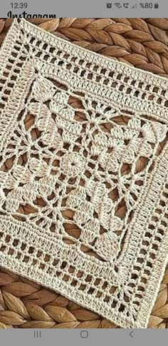 a crocheted doily is sitting on top of a wicker tablecloth