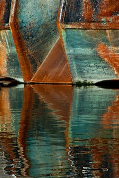 an old rusted boat sitting in the water