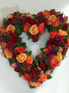 a heart - shaped arrangement of flowers arranged in the shape of a flowery heart