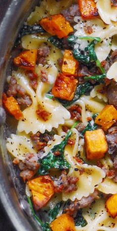 pasta with meat, cheese and spinach in a pan