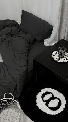 a black and white photo of a bed in a room with a rug on the floor