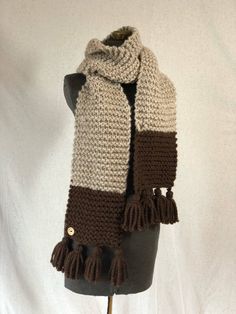 "This is a ready to Ship Product This super scarf is a ribbed pattern made with a wool blend yarn that is super soft and incredibly warm, making it the perfect scarf to wrap yourself up in on a snowy winter day. The scarf is mostly tan with 6 1/2 inches of chocolate brown on each end This scarf has adorable tassel detailing to finish it off! This scarf goes perfect with the slouchy varsity stipe hat, check it out! 76 inches long and 7 inches wide Materials: made of a wool blend 80%acrylic and 20 Knitted Brown Scarf For Fall, Classic Brown Winter Scarf, Brown Knitted Scarf, Casual Brown Knitted Scarf, Cozy Hand Knitted Brown Scarf, Knitting Blocking, Super Scarf, Brown Scarves, Tassel Scarf