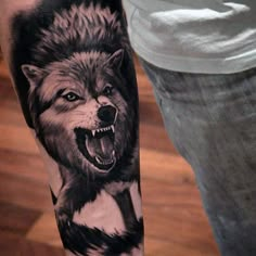 a man's arm with a wolf tattoo on it, and the image is black and white