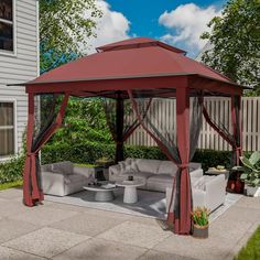 a red gazebo sitting on top of a patio next to a white couch and table