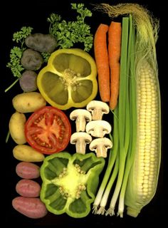 various vegetables are arranged on a black surface