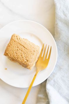 a piece of cake sitting on top of a white plate next to a yellow fork