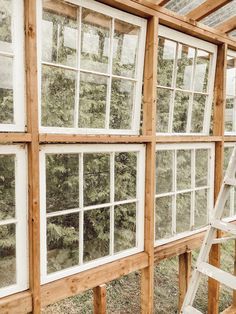 the inside of a house being built with wood and glass windows on each side of it