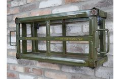 a green metal shelf mounted to a brick wall