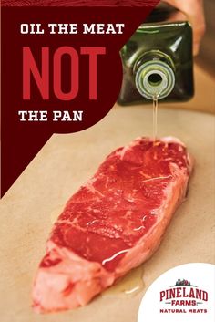 a piece of meat is being drizzled with oil on the meat not the pan