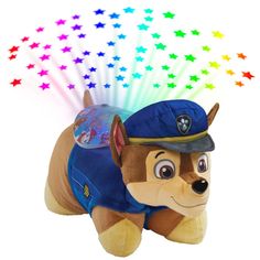 a stuffed animal that is wearing a hat and blue shirt with stars in the background