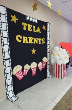 a movie themed party with popcorn buckets and stars on the wall in front of it