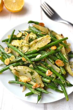 a white plate topped with green beans and almonds