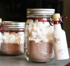 three jars filled with marshmallows sitting on top of a table