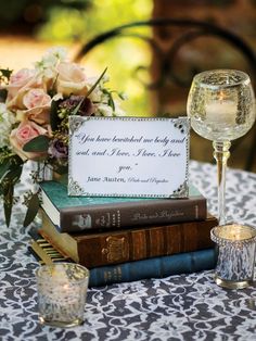 a table topped with books and wine glasses