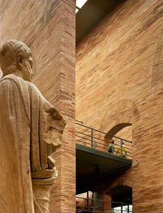 a large statue in front of a brick building