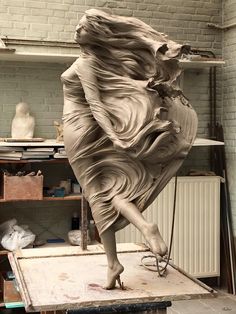 a sculpture of a woman's body is being worked on in an art studio